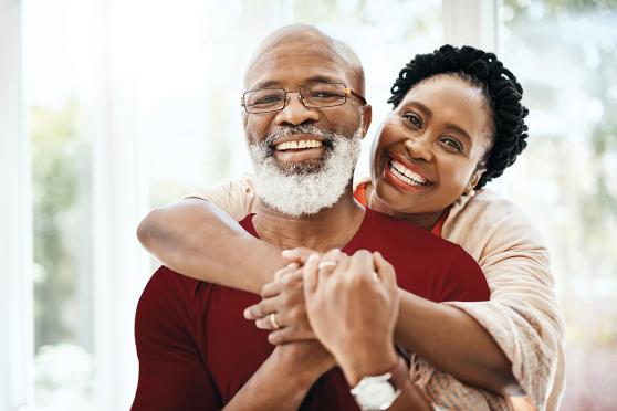 Una mujer abrazando a un hombre por detrás.